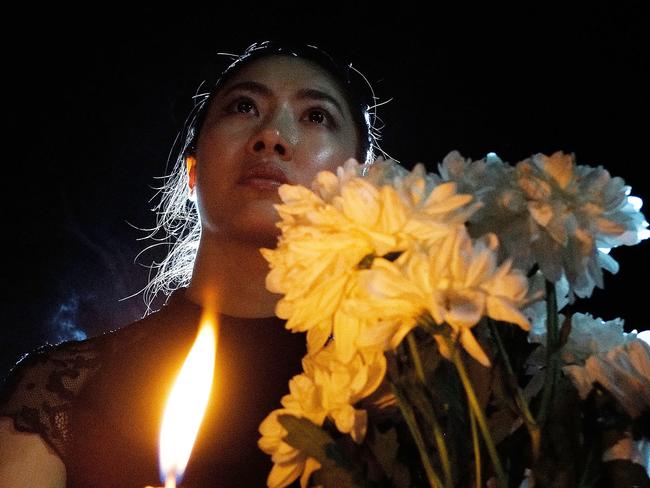 A public member hold a candle during a candle light vigil to remember the victim of the ill-fated flight MH370. Picture: Getty