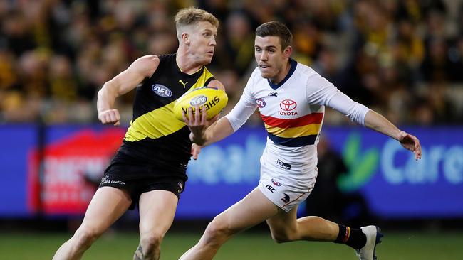 Josh Caddy of the Tigers handpasses the ball ahead of Paul Seedsman of the Crows during their 2018 AFL round 16 match. Picture: Getty Images