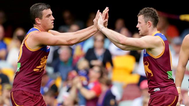 Pearce Hanley of the Lions celebrates a goal with Tom Rockliff.