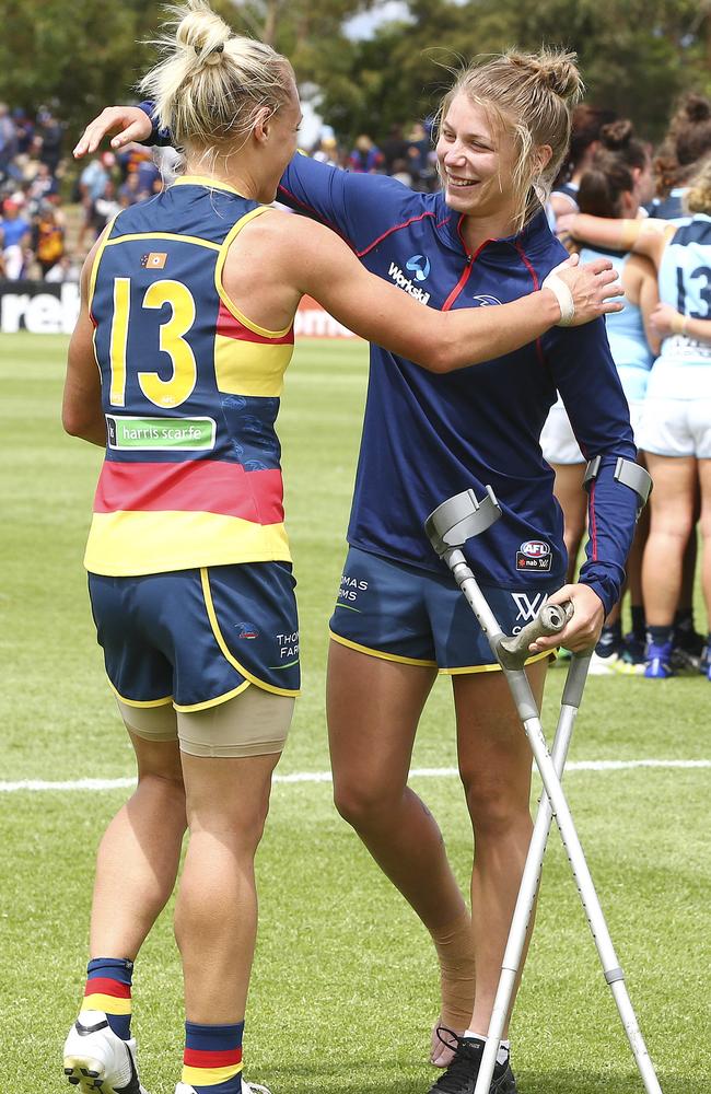 An injured Kellie Gibson congratulates Erinj Phillips after the Crows downed Carlton. She wouldn’t let anyone touch her crutches though, for fear of more injuries. Picture: Sarah Reed