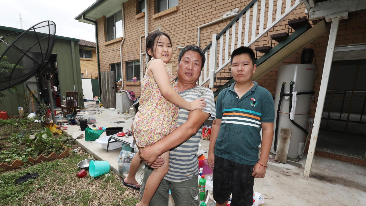 ZhenTao Cong with his kids at their flooded home in St Lucia, Brisbane. Picture: Annette Dew