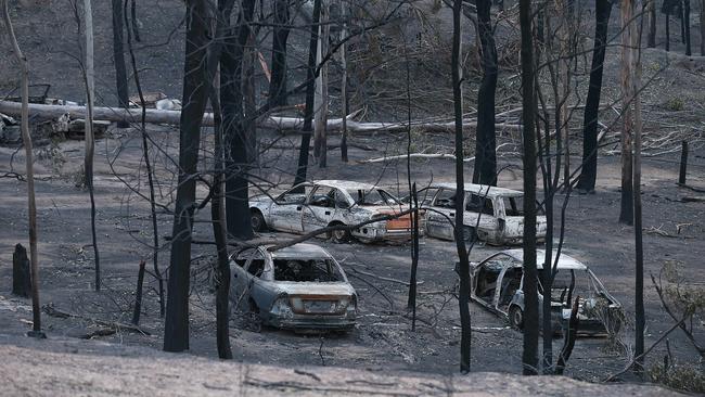 Burnt-out cars and fallen trees in Wytaliba. Picture: Lyndon Mechielsen