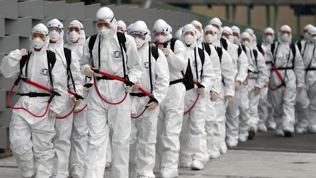 South Korean soldiers wearing protective gear move to spray disinfectant as part of preventive measures against the spread of the COVID-19. Picture: YONHAP/AFP