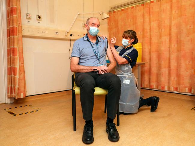 Andrew Pollard, Director of the Oxford Vaccine Group, and a professor of paediatric infection and immunity receives the Oxford University/AstraZeneca COVID-19 vaccine from nurse Sam Foster at the Churchill Hospital in Oxford. Picture: AFP