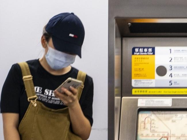 A person wearing a protective mask stands next to signage for digital payment services Alipay by Ant Group, an affiliate of Alibaba Group Holding Ltd., top left, and WeChat Pay by Tencent Holdings Ltd., top right, displayed above a ticket vending machine at an MTR station in Hong Kong, China, on Tuesday, Sept. 1, 2020. BillionaireÂ Jack Ma'sÂ Ant GroupÂ is poised to pull off what could be the biggest initial public offering ever by simultaneously listing in Hong Kong and Shanghai. Photographer: Chan Long Hei/Bloomberg