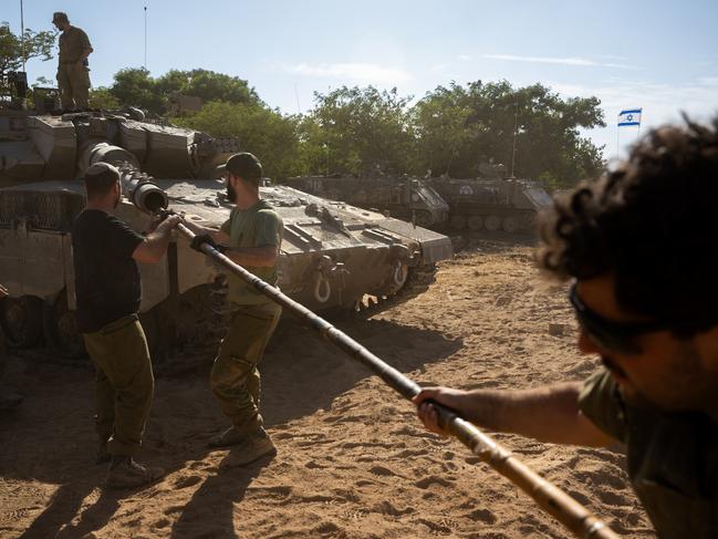 IDF soldiers clean the barrel of a tank in southern Israel. Picture: Getty Images