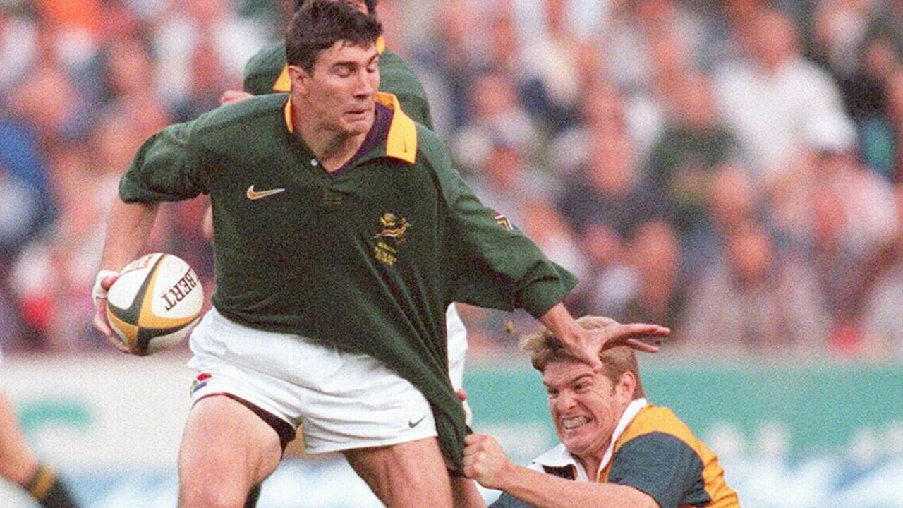Wallabies star Tim Horan grabs Springbok Pieter Rossouw at Ellis Park in 1998.