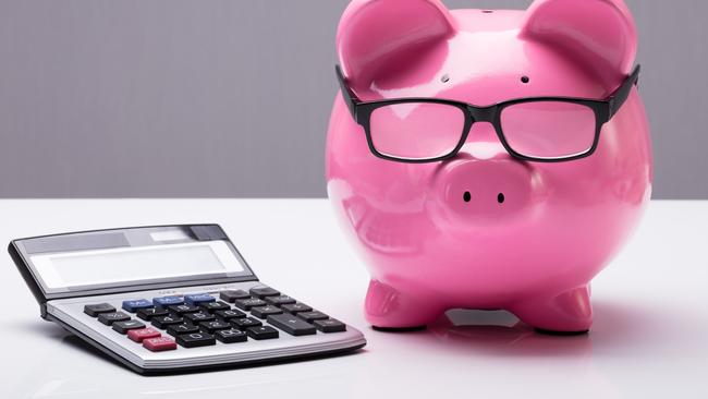 Close-up Of A Piggybank With Eyeglasses And Calculator On Desk; investing superannuation money calculations generic