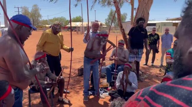 Territory Coroner Elisabeth Armitage is greeted in Yuendumu by senior Warlpiri men.