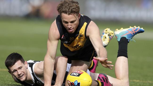 Glenelg’s Michael Virgin pounces on the loose ball ahead of Port’s Sam Davidson. Picture SARAH REED