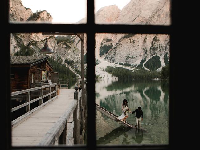 Magdalena Glowacka of Fotomagoria used a window to shoot this couple outside in Lago di Braies, Italy.