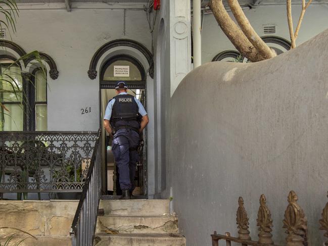 Police enter the Redfern unit where two men were found dead in a boarding house. Picture / Monique Harmer