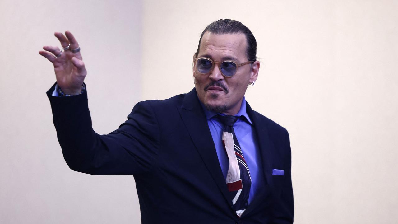 US actor Johnny Depp waves as he departs court. (Photo by JIM LO SCALZO / AFP)