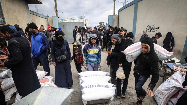 Displaced Palestinians receive food aid at the United Nations Relief and Works Agency for Palestine Refugees (UNRWA) centre in Rafah. Picture: AFP