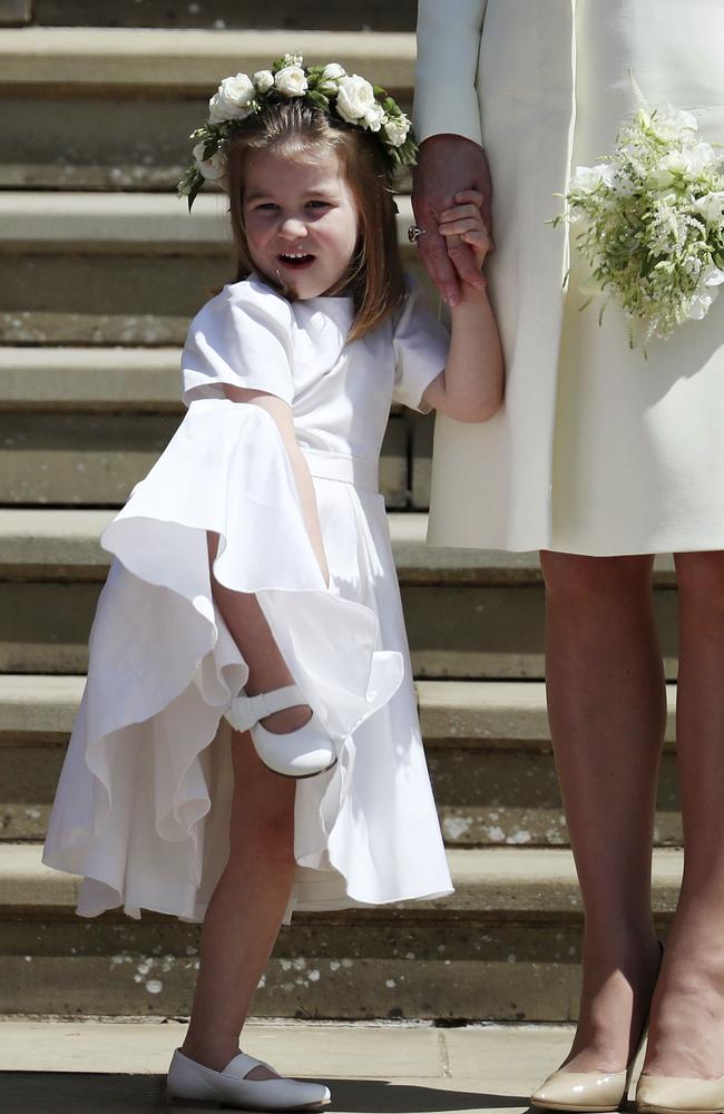 Princess Charlotte looks at Meghan Markle and Britain's Prince Harry on the steps of St George's Chapel. Picture: Jane Barlow/pool photo via AP.