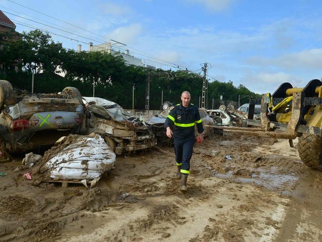 A French firefighter walks among at the wreckage of cars as they carry out the flood damaged vehicles removal in Alfafar, south of Valencia, in the aftermath of deadly flooding. Picture: AFP