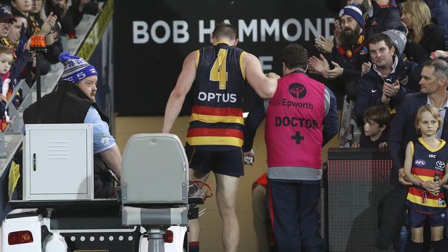 Adelaide’s Josh Jenkins taken from the Adelaide Oval playing field with a knee injury late in the Crows Round 13 game. Picture: Sarah Reed