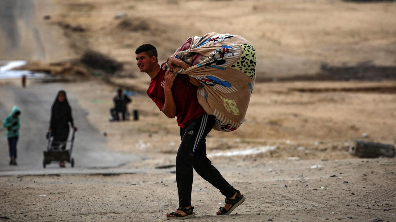 TOPSHOT - Palestinians carry their belongings as they prepare to flee Rafah in the southern Gaza Strip on May 13, 2024, amid the ongoing conflict between Israel and the Hamas militant group. (Photo by AFP)