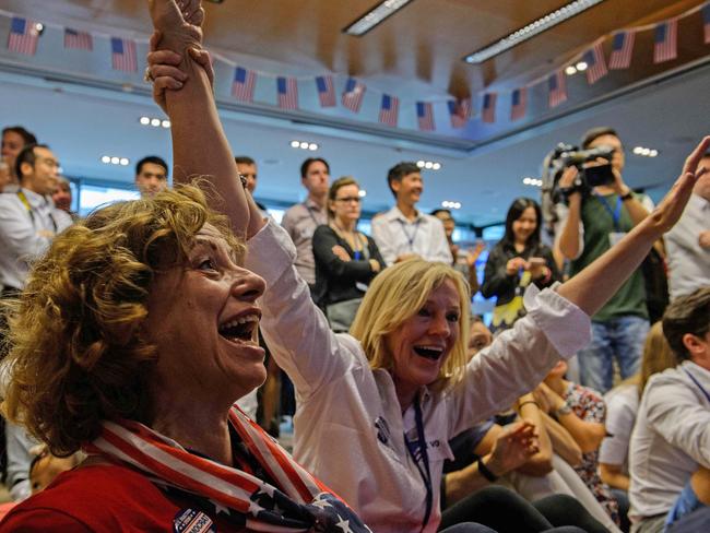 Supporters of Hillary Clinton react as Clinton secures Virginia as they watch live coverage of the US elections at an event organised by the American Chamber of Commerce in Hong Kong on November 9, 2016. Share markets collapsed and the dollar tumbled against the yen and the euro as Donald Trump looked on course to win the race for the White House, in a stunning upset with major implications for the world economy. / AFP PHOTO / ANTHONY WALLACE