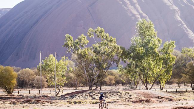 A child rides a bike at Mutitjulu, the indigenous community on the far side of Uluru, Northern Territory. Picture: Jason Edwards