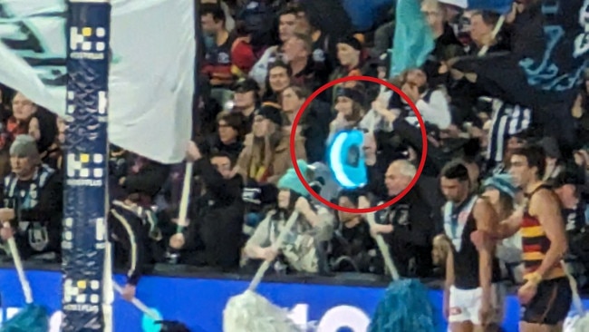 A Port Adelaide cheer squad member has been reprimanded over the use of a light-up drum that was used to distract Crows players lining up for goal at Saturday night’s Showdown