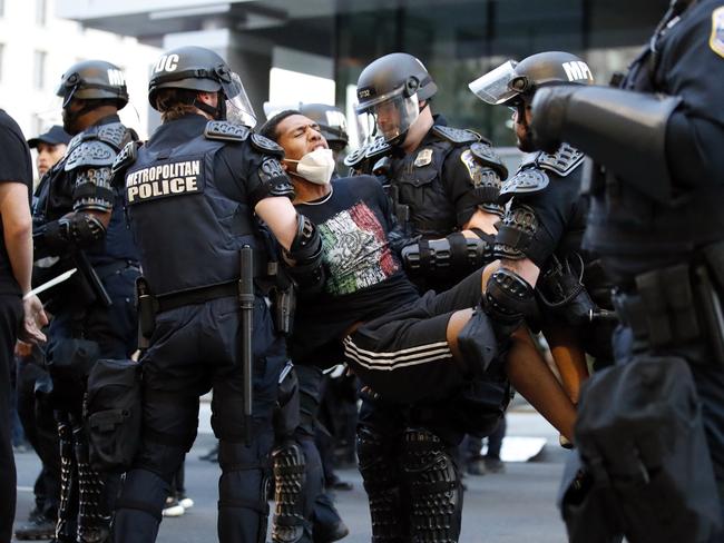 A demonstrator is taken into custody by police after a curfew took effect during a protest over the death of George Floyd near the White House in Washington. Picture: AP