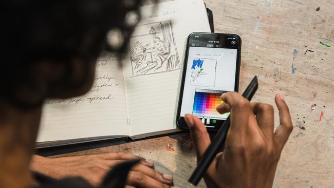 A woman changes the colour of her drawing in the Moleskine app.