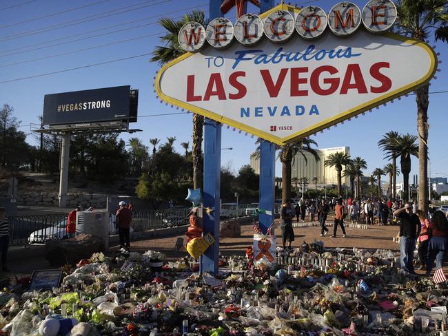 Flowers, candles and other items surround the famous Las Vegas sign at a makeshift memorial for victims of the mass shooting. Picture: AP