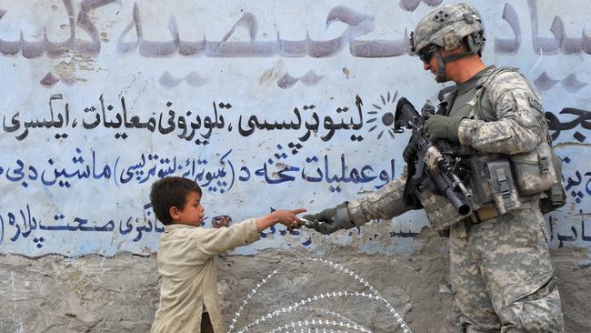 A US soldier presents a gift to an Afghan child during a patrol at Khogyani in Nangarhar. Picture: AFP