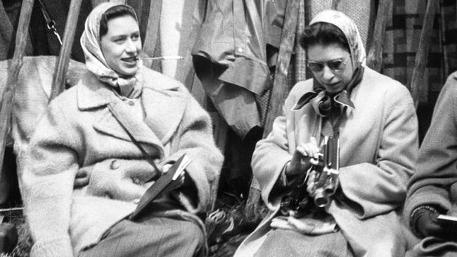 The Queen and Princess Margaret remained close through their lives. Here, Princess Margaret smokes while the Queen fiddles with her camera at Badminton. Picture: Getty Images.