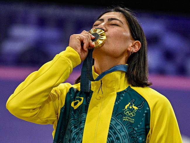 Saya Sakakibara kisses her gold medal standing on the podium after winning the Women's Cycling BMX Racing finals. Picture: Julien De Rosa / AFP