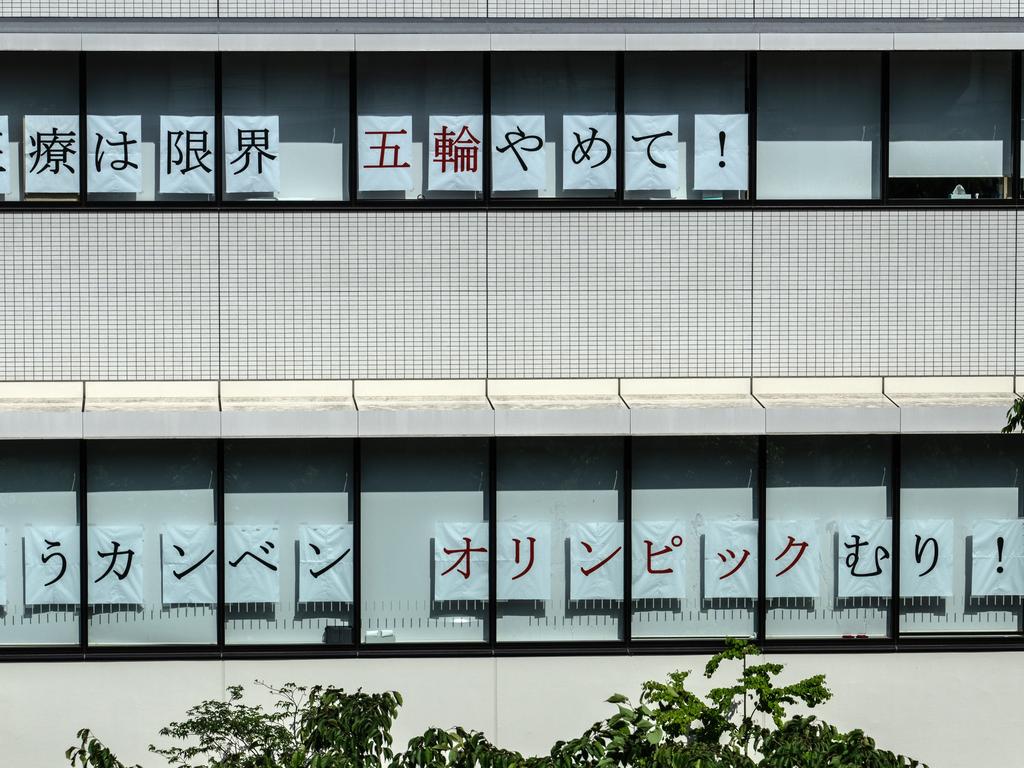 Posters reading ‘Medical capacity reached its limits. Stop the Olympics! – Give us a break. The Olympics are impossible!’ are displayed in the windows of Tachikawa Sogo Hospital on May 10 in Tokyo. Picture: Carl Court