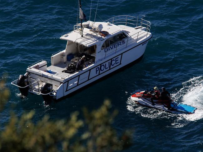 Police and lifesavers search the scene below the cliffs at Watsons Bay on Friday. Picture: Justin Lloyd