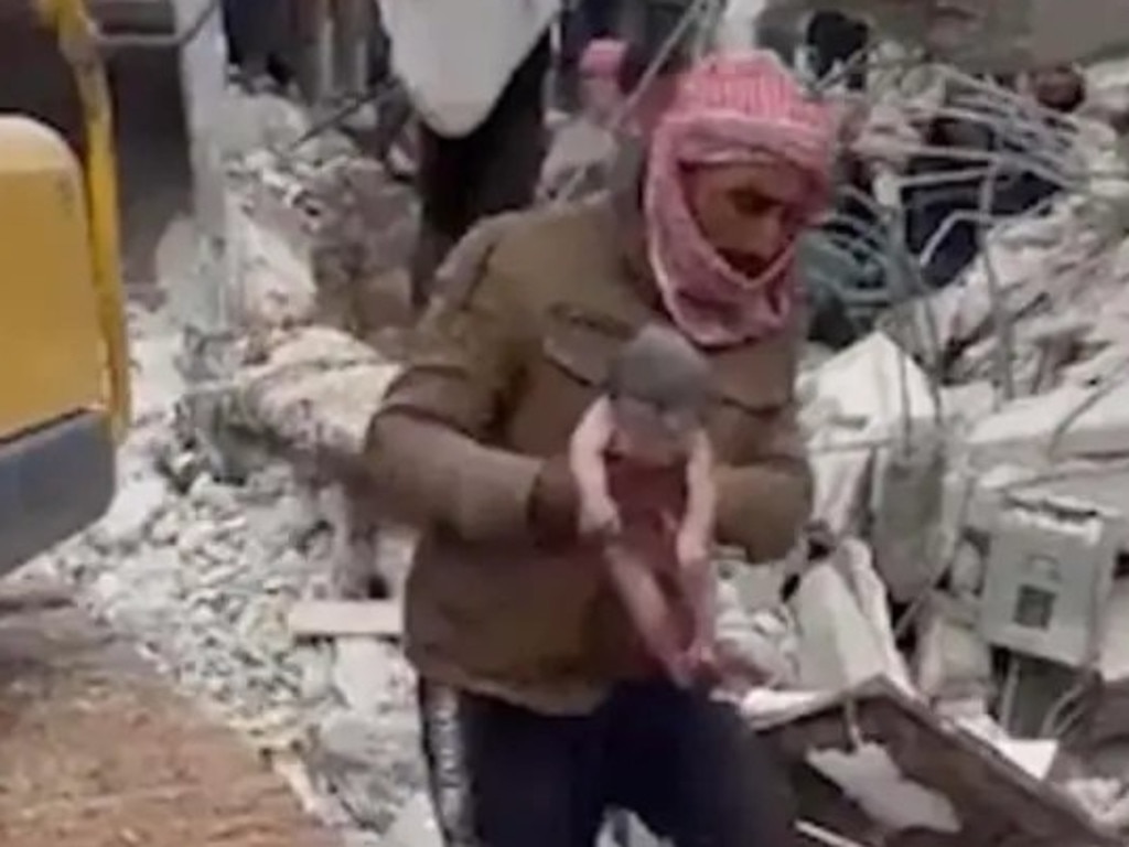 A man rushes the “miracle baby” from the quake rubble in Syria.