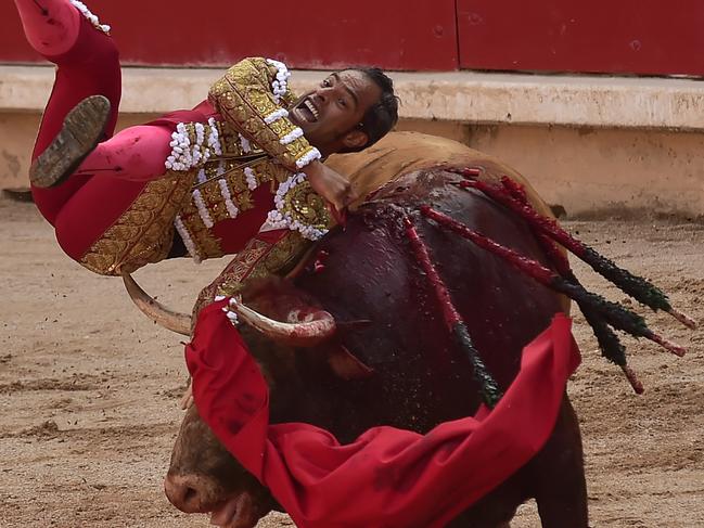 Colombian bullfighter Luis Bolivar is pushed by Cebado Gago's bull in the bullring at the San Fermin Festival in Pamplona, northern Spain, Monday, July 9, 2018. Revellers from around the world flock to Pamplona every year to take part in the eight days of the running of the bulls. (AP Photo/Alvaro Barrientos)