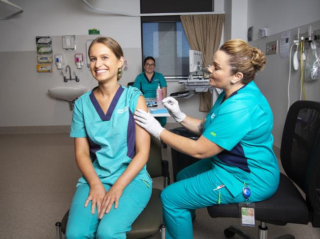 Registered Nurse Zoe Park receives Queensland’s first COVID-19 vaccine from clinical nurse consultant Kellie Kenway at Gold Coast University Hospital on February 22. Picture: Nigel Hallett