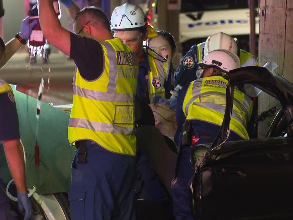 Pictured are emergency services attending a car crash after a Police pursuit on Railway Parade, Canley Vale when the vehicle being pursued lost control and hit a telegraph pole trapping two people. Picture: TNV