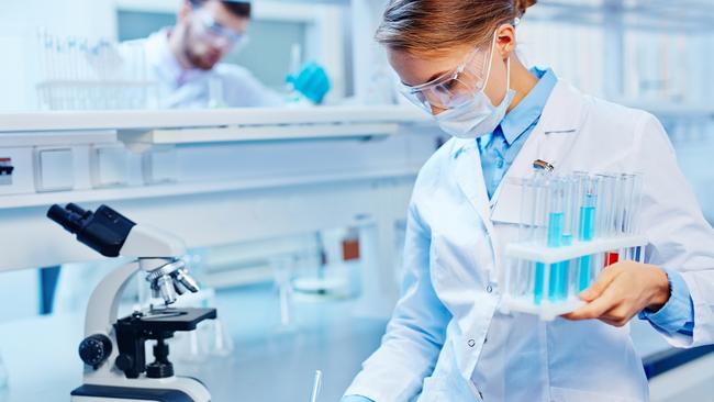 HEALTH:  Young woman with flasks making notes in laboratory. Biotechnology research  laboratory generic