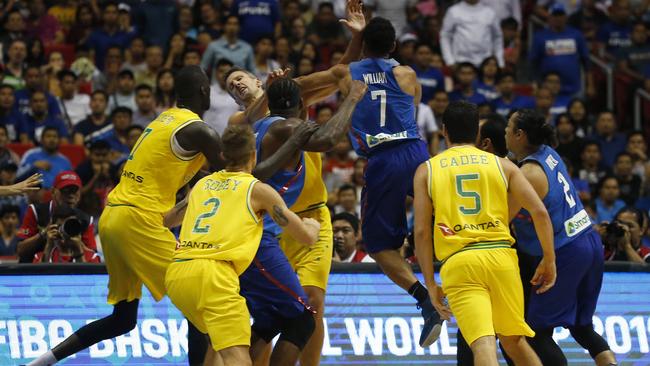 The Philippines' Jason William, centre, jumps to hit Australia's Daniel Kickert centre left as others rush to break the brawl during the FIBA World Cup Qualifiers Monday, July 2, 2018 at the Philippine Arena in suburban Bocaue township, Bulacan province north of Manila, Philippines. Australia defeated the Philippines 89-53 via default following a brawl in the third quarter. (AP Photo/Bullit Marquez)