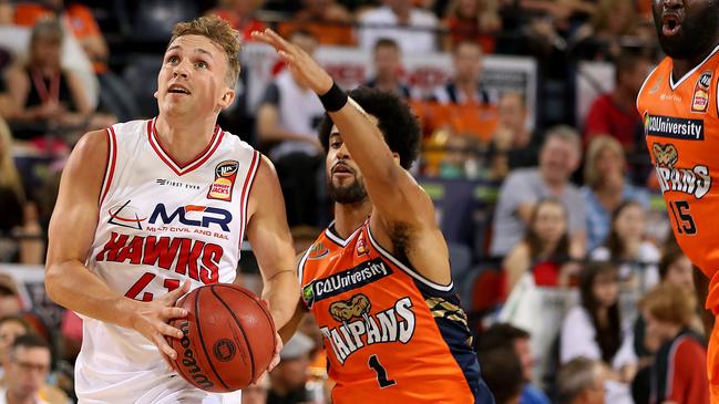 Hawks Emmett Naar gets past Melo Trimble and Nathan Jawai during the Round 8 NBL match between Cairns Taipans and Illawarra Hawks at Cairns Convention Centre in Cairns, Friday, December 7, 2018. (AAP Image/Marc McCormack) NO ARCHIVING, EDITORIAL USE ONLY