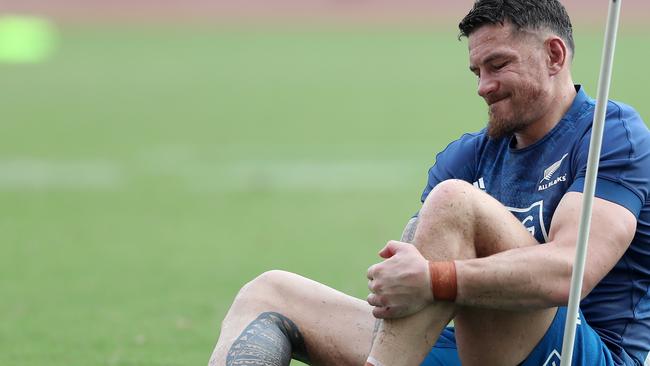 Sonny Bill Williams of the All Blacks takes his boots off during a training session.