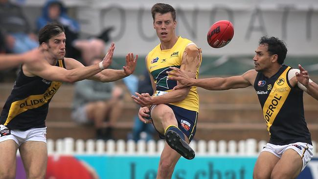 Star Eagle Jack Hayes gets his kick away under pressure from Glenelg’s Max Proud (left) and Marlon Motlop at Woodville Oval on Saturday. Picture: Dean Martin