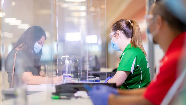 NT Department of Health workers in the Darwin International Airport’s border control area, where travellers are screened to see if they are free to come in or must be sent to mandatory quarantine. Picture: Che Chorley