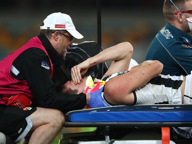 BRISBANE, AUSTRALIA - AUGUST 15: Brody Mihocek of the Magpies leaves the ground with an injury during the round 12 AFL match between the Melbourne Demons and the Collingwood Magpies at The Gabba on August 15, 2020 in Brisbane, Australia. (Photo by Jono Searle/AFL Photos/via Getty Images)