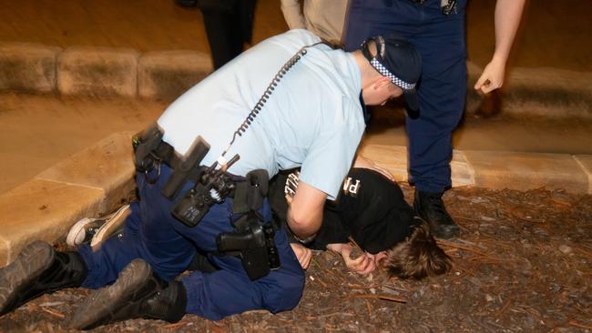 Cops tackling a teen after he fled from police. Picture: Damian Hofman