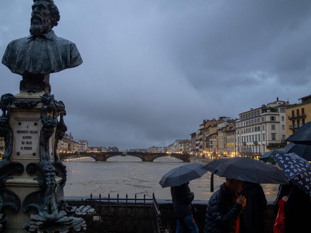 People watch the flow of the Arno River in Florence. Picture: Federico Scoppa/AFP