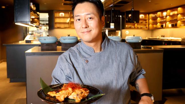 Executive sous chef Chris Jang holding a Robata grilled teriyaki chicken in new restaurant Izakaya Publico, in Hotel Indigo. Picture: Steve Pohlner