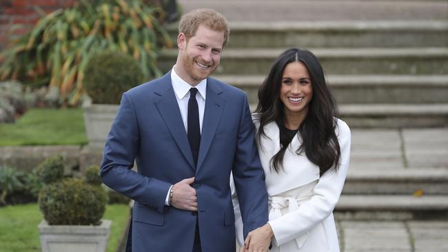 Britain's Prince Harry and his fiancée US actress Meghan Markle pose for a photograph in the Sunken Garden at Kensington Palace in west London on November 27, 2017, following the announcement of their engagement. Britain's Prince Harry will marry his US actress girlfriend Meghan Markle early next year after the couple became engaged earlier this month, Clarence House announced on Monday. / AFP PHOTO / Daniel LEAL-OLIVAS