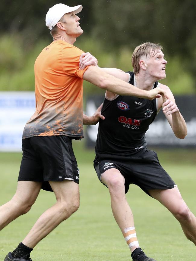 Dean Brogan works with Sam Hayes during the Power’s pre-season camp on the Gold Coast. Picture SARAH REED