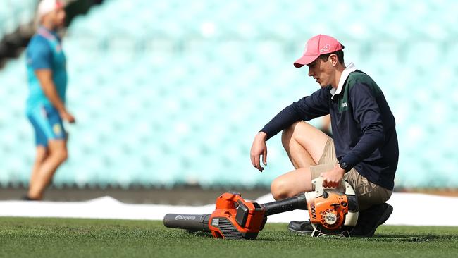 A member of the ground staff uses blowers to dry an area near the centre wicket on Thursday. Picture: Getty